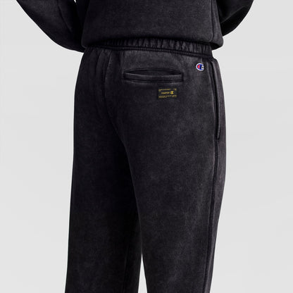 Back view of dark grey Mineral Wash Open Hem Pant featuring a back pocket, a rectangular Champion brand label, and a small logo embroidered near the waist.