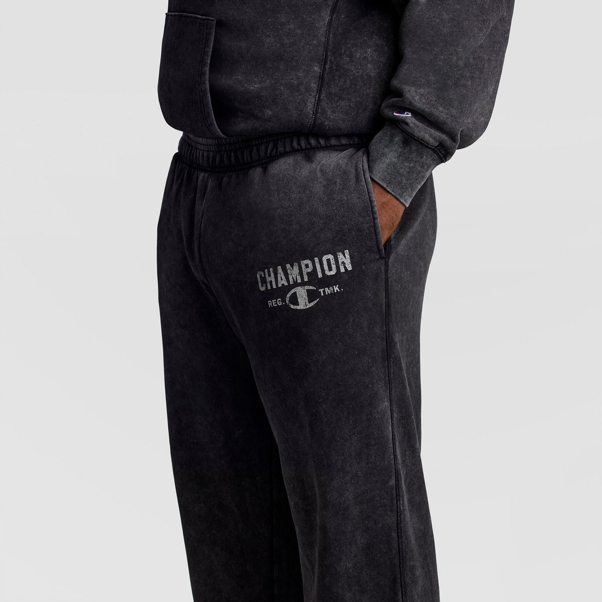 Dark gray Champion Mineral Wash Open Hem Pant sweatpants featuring a distressed logo printed on the thigh for a vintage look.