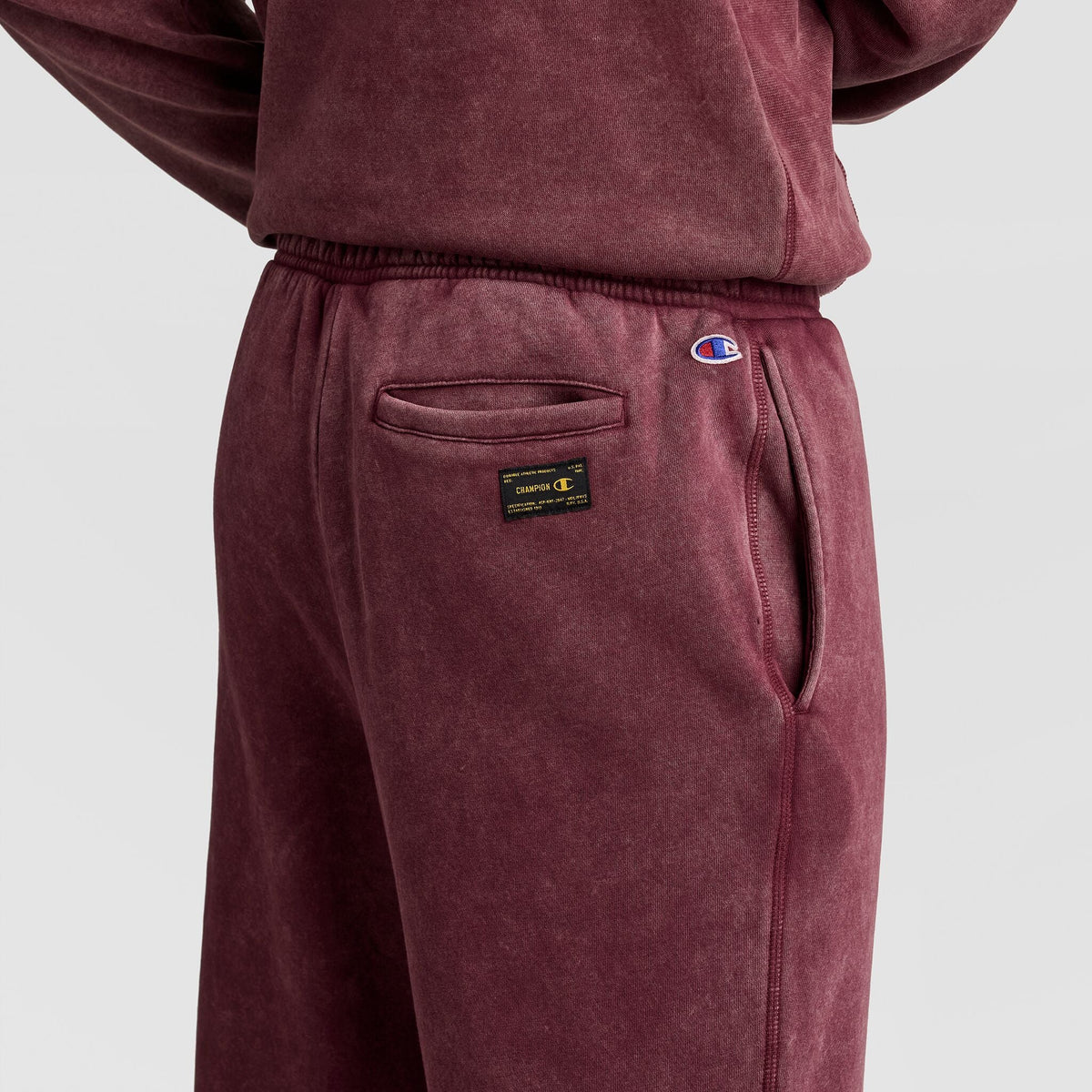 Maroon Champion Mineral Wash Open Hem Pant featuring a back pocket, a logo patch, and a small embroidered logo on the hip.