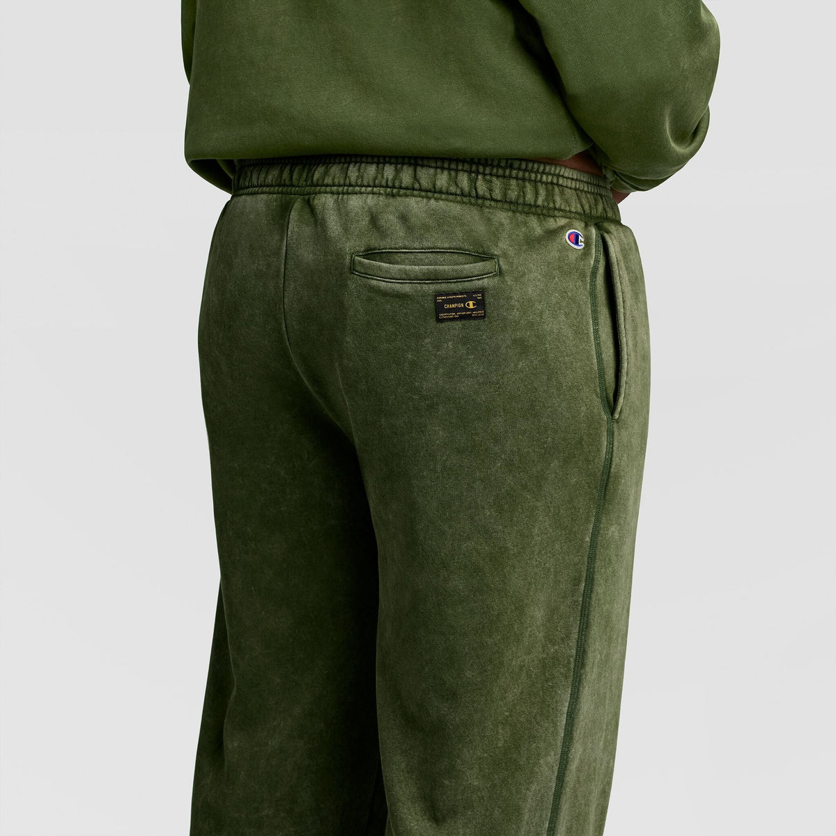Back view of olive green Mineral Wash Open Hem Pant featuring an elastic waistband, a back pocket, and a small woven label.