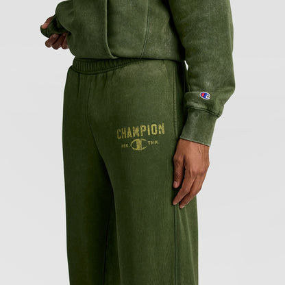 Mineral Wash Open Hem Pant in olive green athletic fleece with an open hem and a distressed gold Champion logo on the thigh for a vintage look.