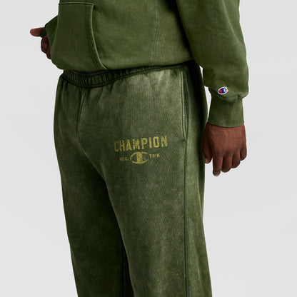 Champion Mineral Wash Open Hem Pant in olive green athletic fleece with an open hem and a faded logo printed on the thigh.