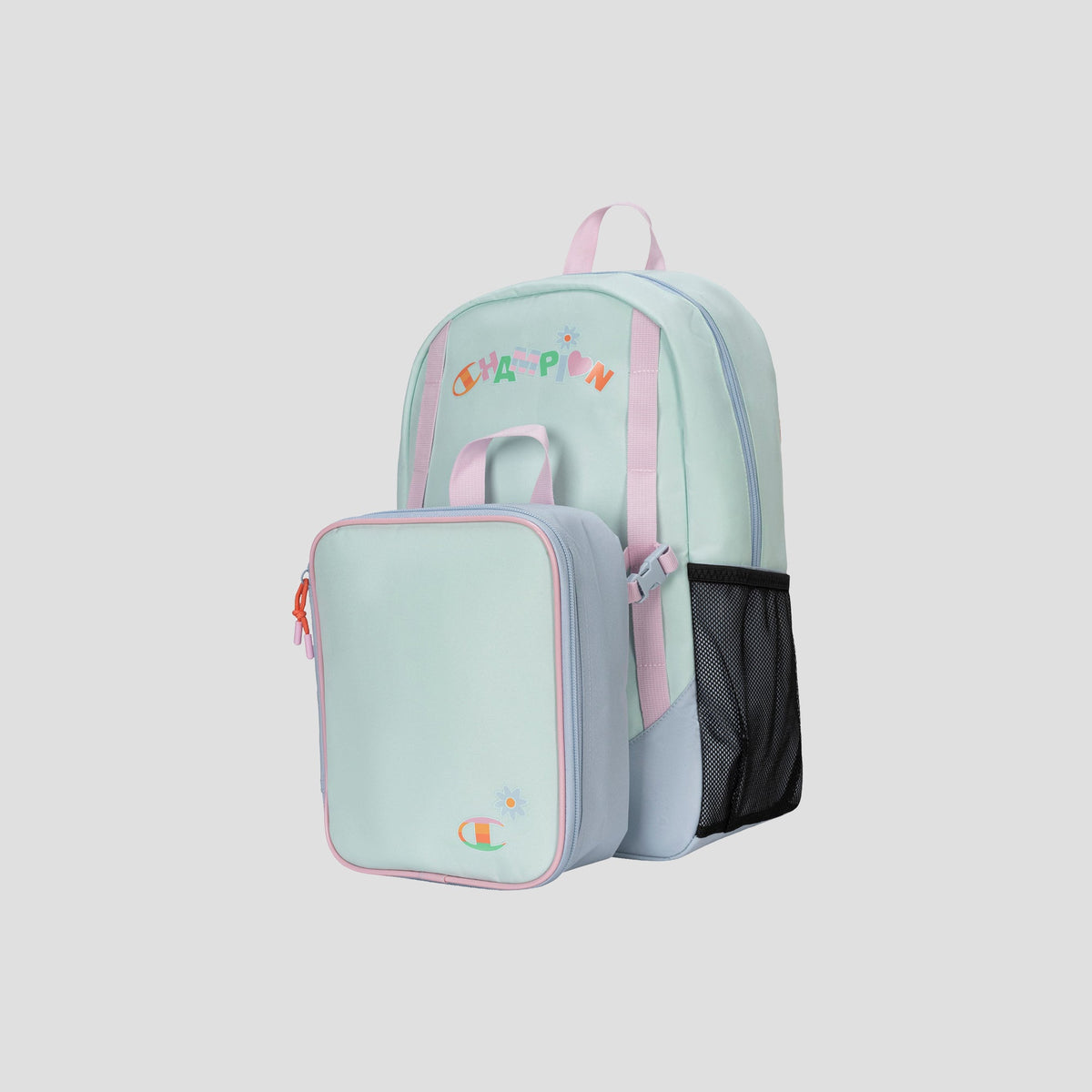 The Champion Kids’ Mode Lunch Kit & Backpack Combo features a pastel mint green backpack with pink straps, a mesh side pocket, and colorful CHAMPION text. A matching mint green insulated lunch box is attached to the front, making this youth backpack both stylish and practical. The background is light gray.