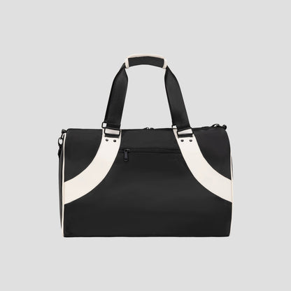 The Champion Oracle Duffel Bag in black, featuring white handles and accents, is displayed against a light gray background. This sports bag includes a zippered front pocket and short carrying straps.