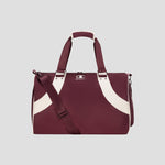 The Champion Oracle Duffel Bag in maroon, featuring white curved stripes, top handles, a shoulder strap, and a small Champion logo on the front, is displayed against a plain light gray background. This versatile gym bag is ideal for both workout sessions and travel.