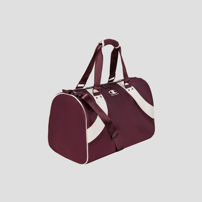 The Champion Oracle Duffel Bag, featuring a maroon body with white curved stripes, white handles, and maroon shoulder straps, is displayed on a plain light gray background.