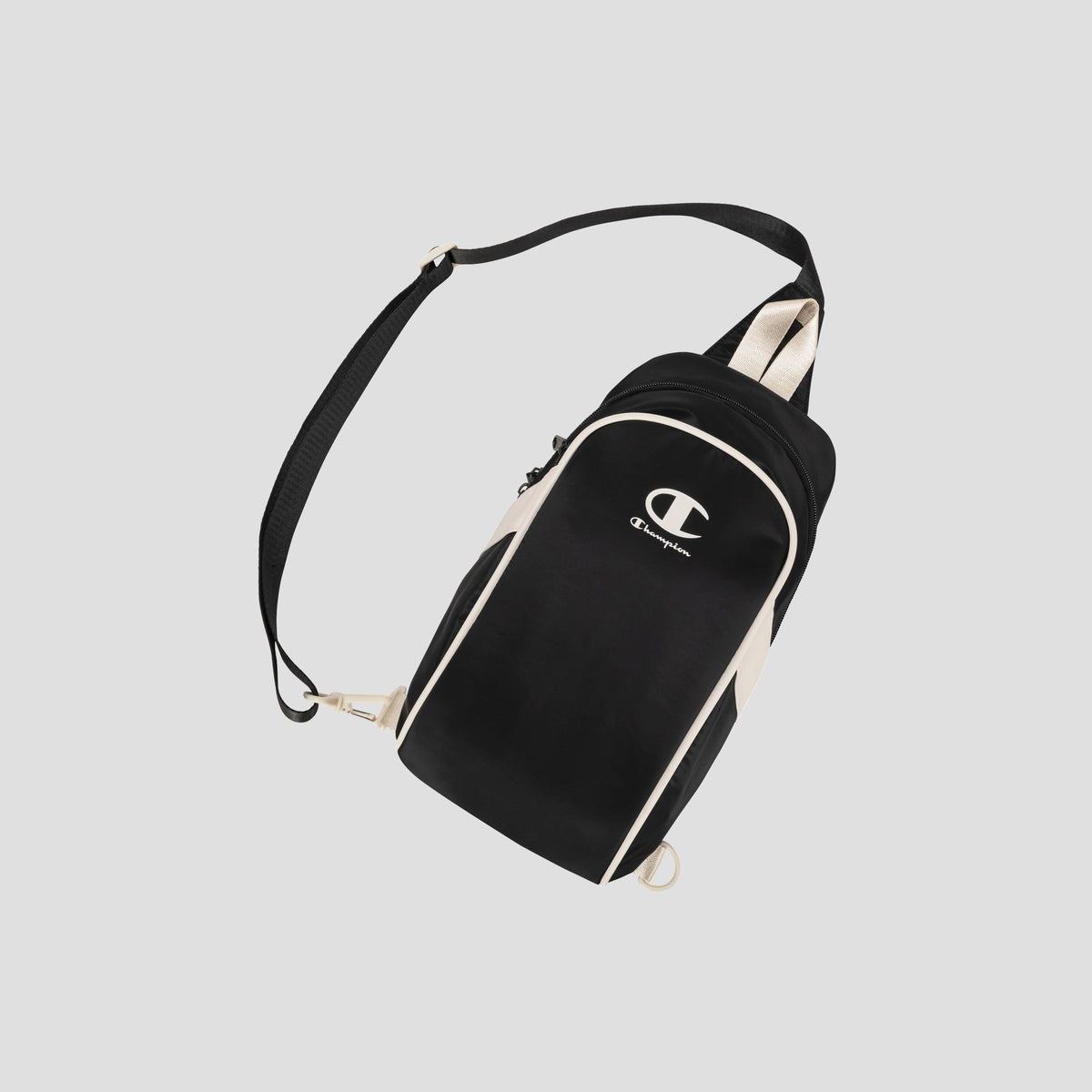 The Oracle Sling Pack by Champion is a black and beige crossbody bag featuring an adjustable strap and a white Champion logo on the front, displayed against a light gray background. Ideal as a gym bag or for everyday use.