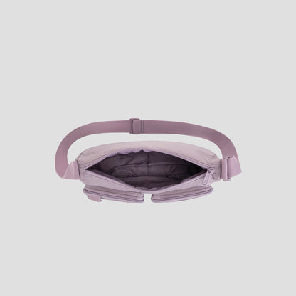 A top view of the open Champion Quartz Small Messenger Bag in light purple, made from lightweight nylon with a wide strap, showcasing its empty, spacious interior and zippered compartments against a plain gray background—ideal as a stylish crossbody messenger bag for travel or everyday use.