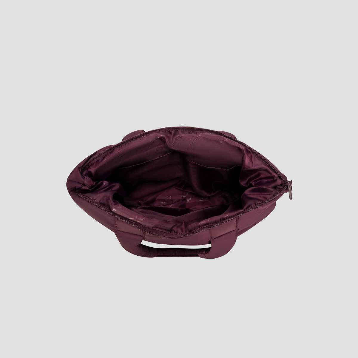 A top-down view of the Champion Quilted Billie Tote in open maroon, featuring a chic quilted design, multiple inner pockets, and a secure zipper closure. The empty interior is displayed against a light gray background—making it an ideal choice for everyday use.