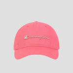The Champion Script Embroidery Adjustable Cap is crafted from vibrant pink washed cotton twill and showcases beige Champion script embroidery on the front. This cap features an adjustable strap and is photographed against a light gray background.
