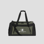 The Champion Stadium Duffel Bag is shown in olive green and black, featuring dual handles, a shoulder strap, front zip pocket, side pockets, and a prominent white Champion logo on the front, set against a plain gray background.