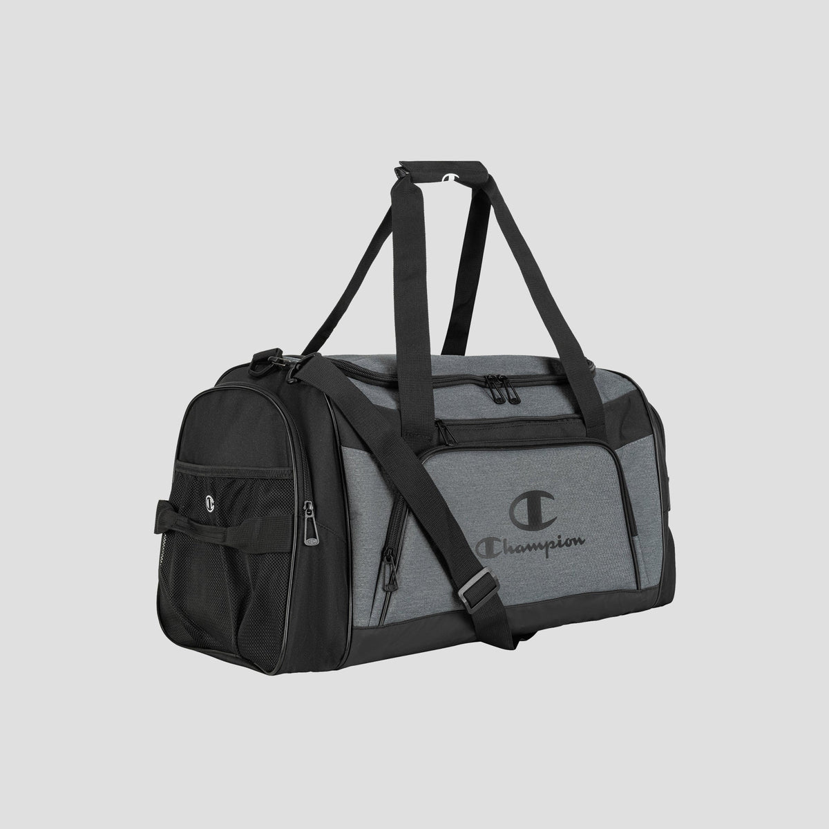 The Champion Stadium Duffel Bag in gray and black, featuring a shoulder strap, multiple zippered compartments, a mesh side pocket, and the Champion logo on the front, is displayed on a plain light gray background.