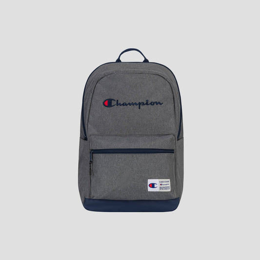 Champion System Backpack in gray and navy blue, designed with multiple storage compartments, a front zipper pocket, and a padded laptop sleeve. The Champion logo is stitched on the main compartment, accompanied by a small Champion patch near the bottom. Product photographed against a plain light gray background.