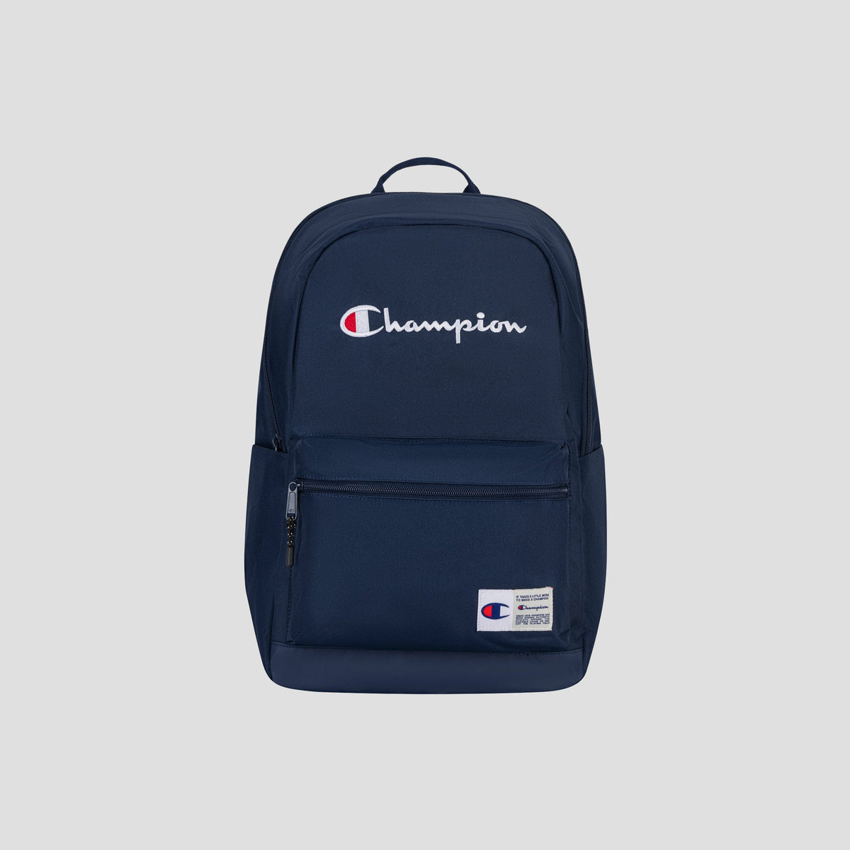 Introducing the Champion System Backpack in navy blue, designed with multiple storage compartments—including a front zipper pocket, side pocket, and a padded laptop sleeve for added convenience. The backpack showcases the distinctive white and red Champion logo on the front, set against a light grey background in the photograph.