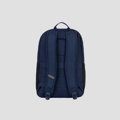 The System Backpack by Champion is displayed from the back against a plain light gray background, showcasing its navy blue color, padded shoulder straps, top carry handle, and multiple storage compartments—including a padded laptop sleeve.