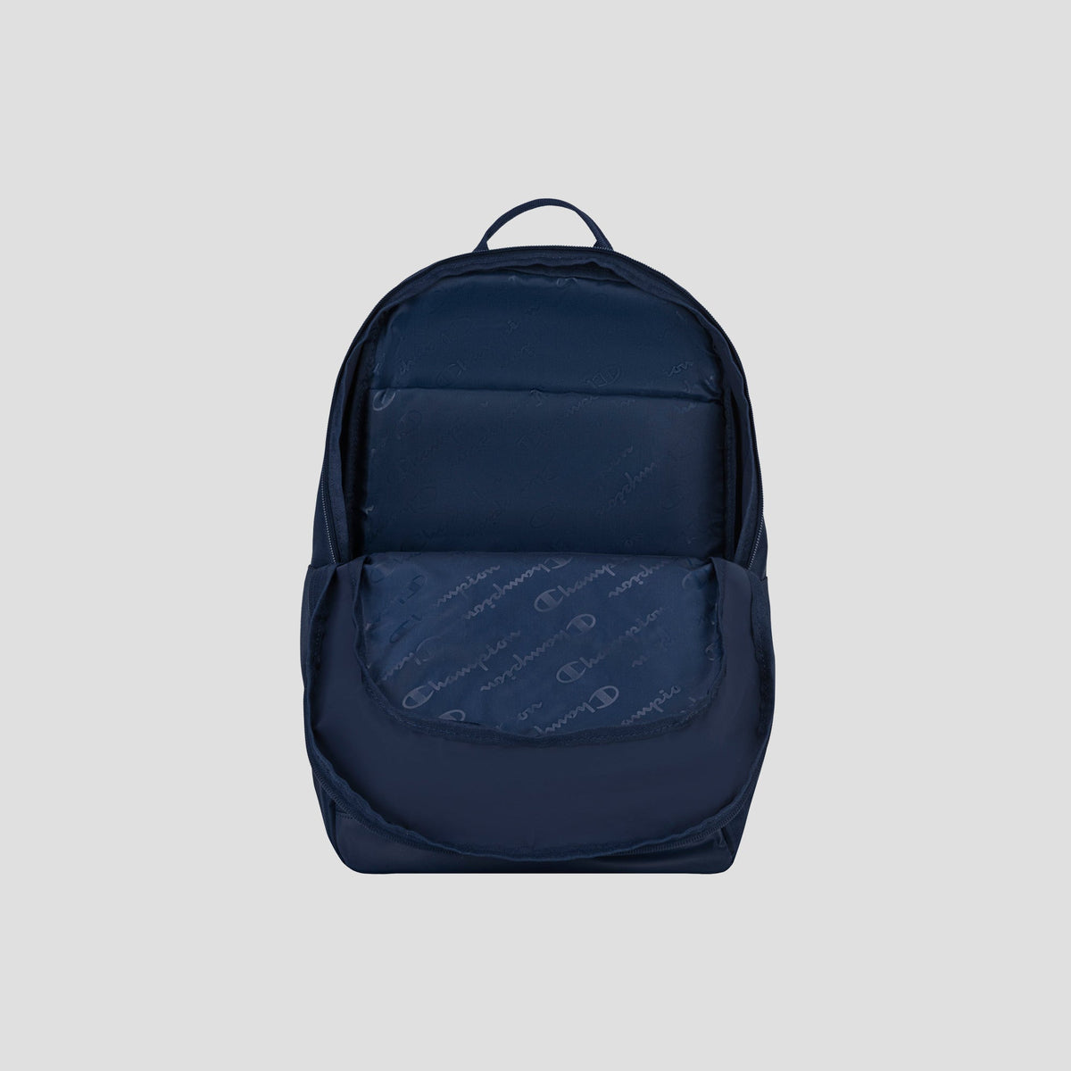 The Champion System Backpack, shown in navy blue against a light gray background, features a front pocket slightly open to reveal its patterned interior and multiple storage compartments.