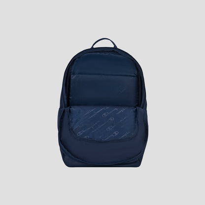 The Champion System Backpack, shown in navy blue against a light gray background, features a front pocket slightly open to reveal its patterned interior and multiple storage compartments.