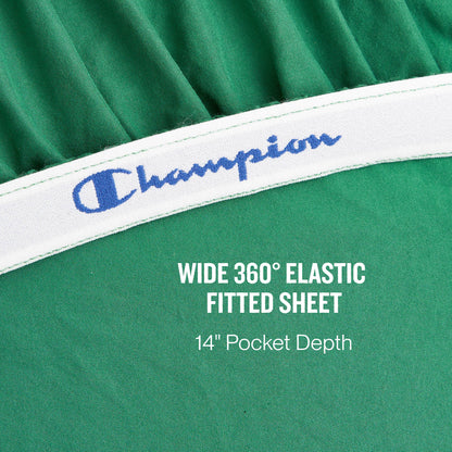 Close-up of a green fitted sheet with a white elastic band featuring the blue Champion logo. Text overlays read: WIDE 360° ELASTIC FITTED SHEET and 14″ Pocket Depth. Experience athletic bedding at its finest with the Peak Comfort Microfiber Sheet Set from Champion, crafted for a secure and comfortable fit with deep pockets.