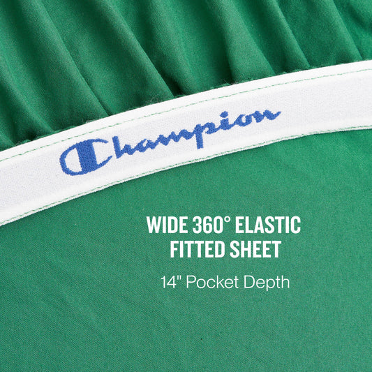 Close-up of a green fitted sheet with a white elastic band featuring the blue Champion logo. Text overlays read: WIDE 360° ELASTIC FITTED SHEET and 14″ Pocket Depth. Experience athletic bedding at its finest with the Peak Comfort Microfiber Sheet Set from Champion, crafted for a secure and comfortable fit with deep pockets.