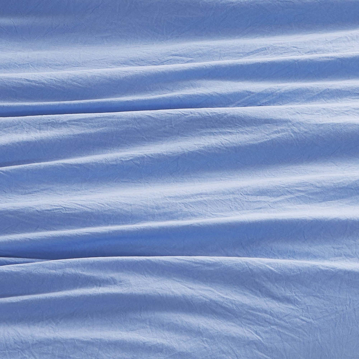 Soft light blue fabric featuring gentle, wavy folds and subtle horizontal creases, creating a textured appearance reminiscent of the Champion Elastic Logo Microfiber Sheet Set by Champion.