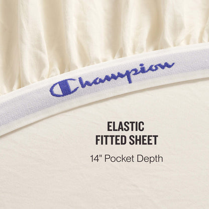 Close-up of the Champion Elastic Logo Microfiber Sheet Set’s cream-colored fitted sheet, featuring a branded elastic band and a 14-inch pocket depth for daily comfort. Text reads: ELASTIC FITTED SHEET 14″ Pocket Depth.