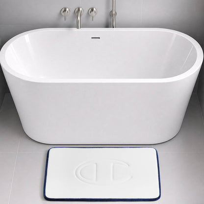A modern white bathtub with a wall-mounted faucet, and a rectangular Champion Quilted Logo Memory Foam Bath Mat, offering cushioned comfort, placed on a gray tiled floor.