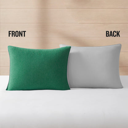 Two pillows from the Champion Reversible Solid Jersey Comforter Sets rest on a white surface against a wood background. The left pillow is green and marked FRONT, while the right pillow is gray and marked BACK, highlighting the reversible design that brings added versatility to any athletic bedding setup.