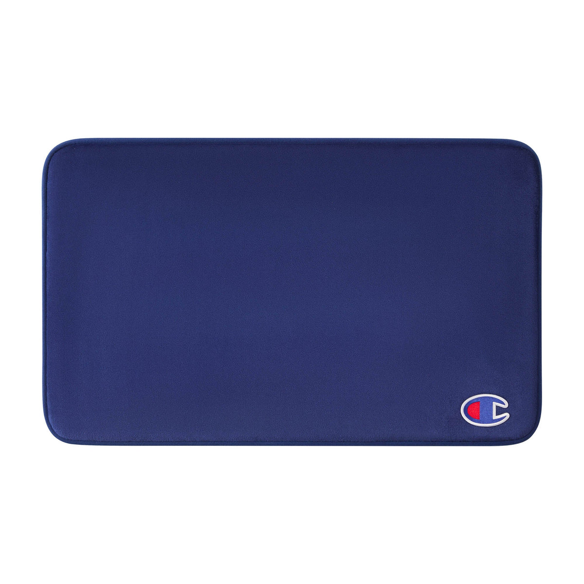 A rectangular, dark blue Logo Patch Memory Foam Bath Mat by Champion features rounded corners and a small Champion logo patch in the lower right corner. Its soft, smooth surface provides a skid-resistant finish for added safety.