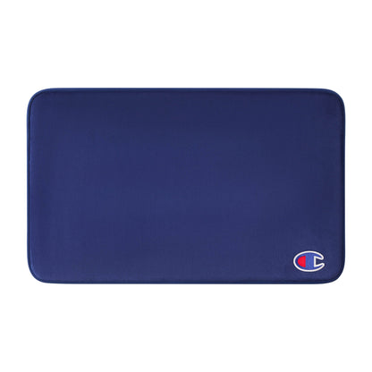 A rectangular, dark blue Logo Patch Memory Foam Bath Mat by Champion features rounded corners and a small Champion logo patch in the lower right corner. Its soft, smooth surface provides a skid-resistant finish for added safety.
