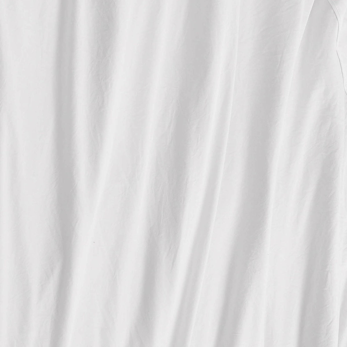 A close-up of a white fabric with soft, vertical folds and subtle wrinkles reveals a slightly textured appearance—beautifully illustrating the smooth feel of the Champion Embroidery Patch Microfiber Sheet Set for athletic-inspired bedding.
