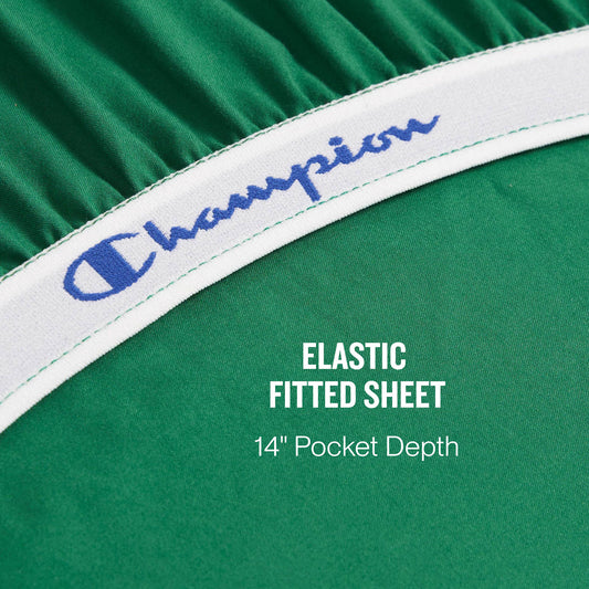 Close-up of a green elastic fitted sheet from the Champion Elastic Logo Microfiber Sheet Set, featuring “Champion” in blue on the white elastic band. Text on the sheet reads: ELASTIC FITTED SHEET 14 Pocket Depth.